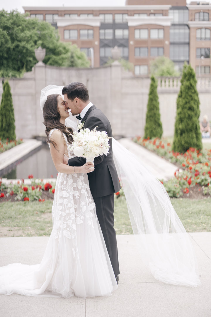 Groom kisses his bride during first look at Congress Park in Saratoga Springs NY