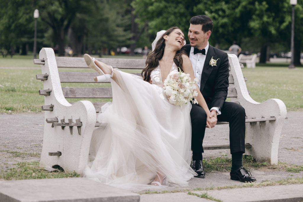 bride and groom laughing on a bench at Hall of Springs in Saratoga NY