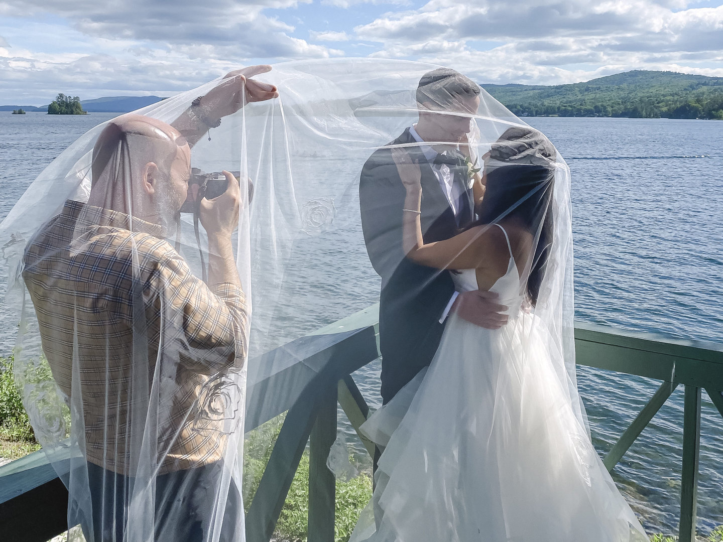 Should You Tip Your Wedding Photographer, shooting a bride and groom on the dock with water and mountains behind