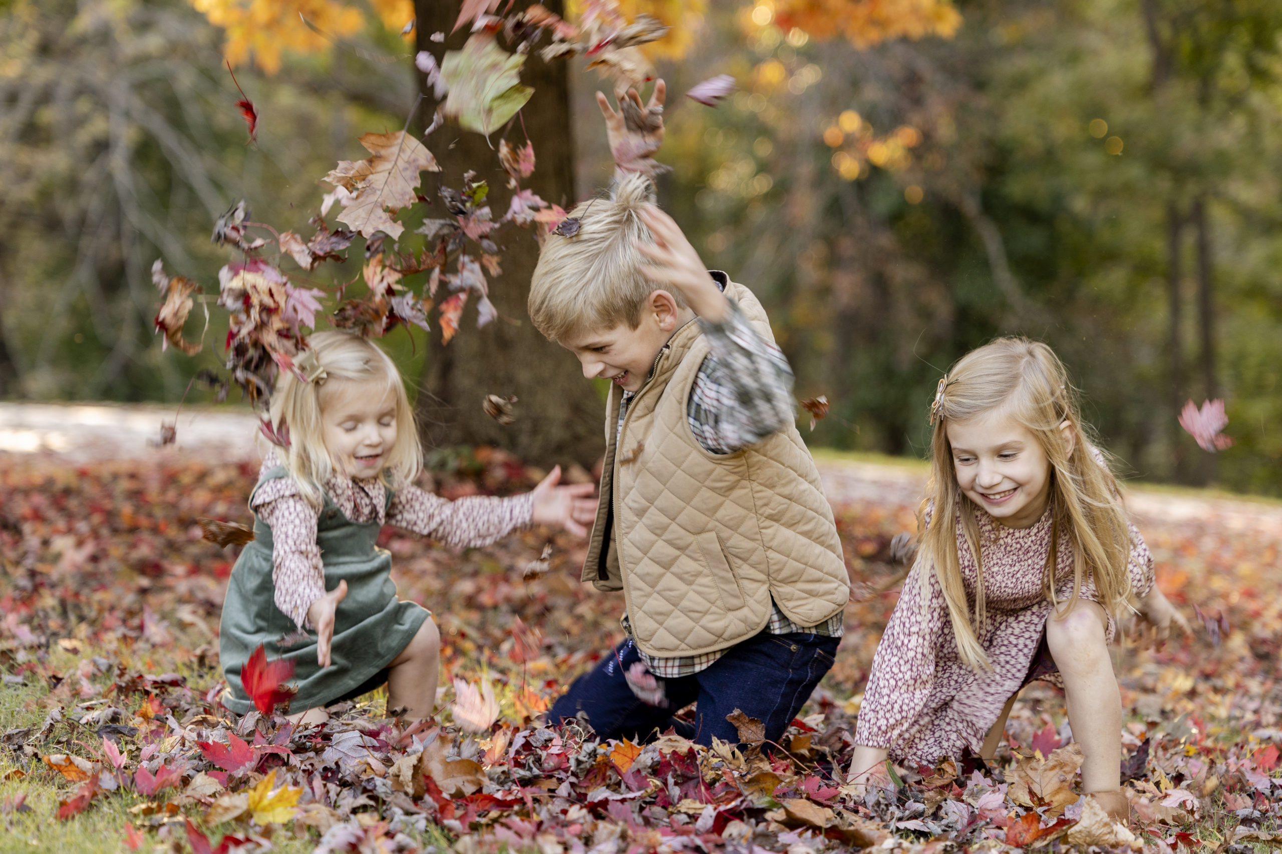 Kids throwing leaves for their fall family photo session