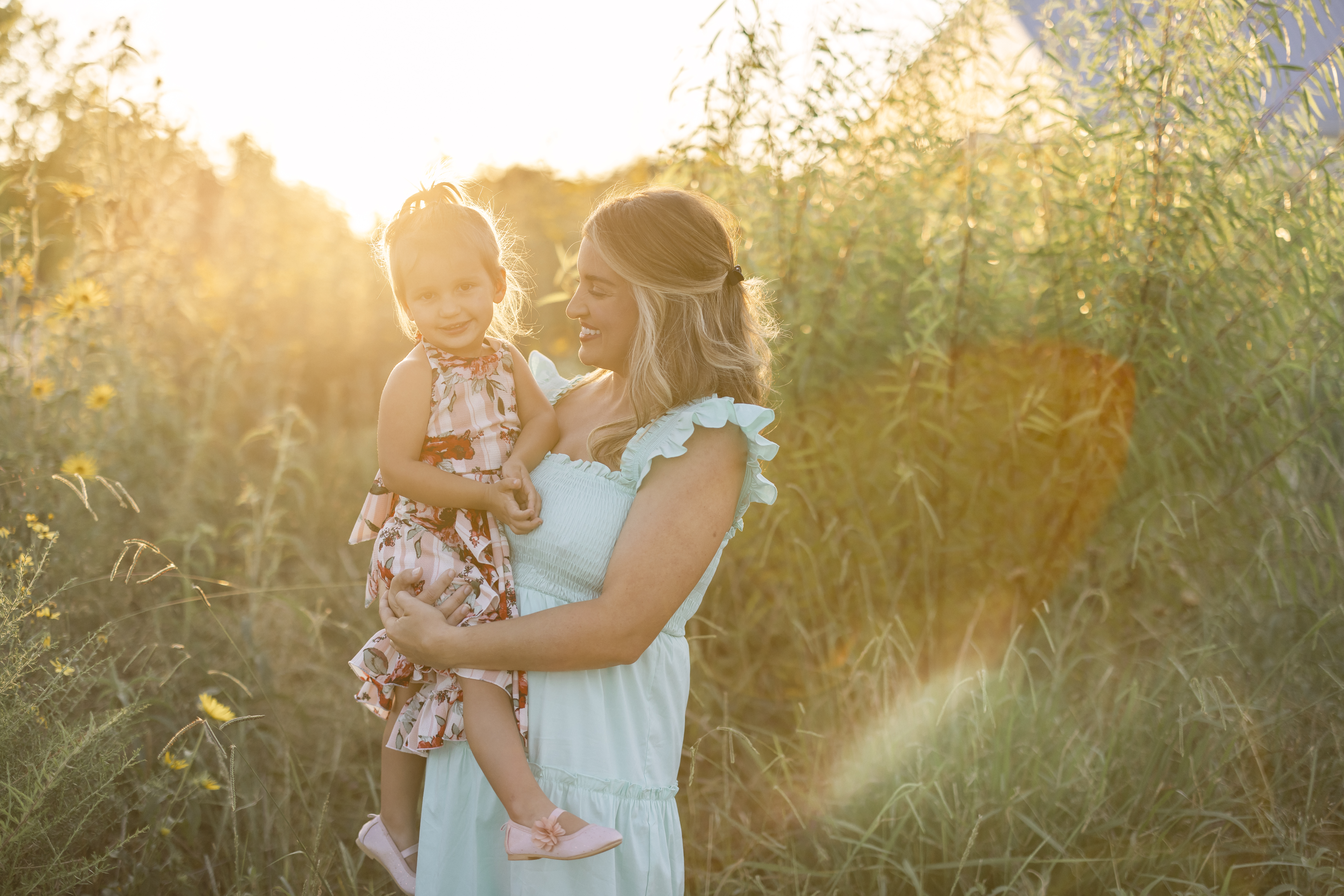 Mommy and Me Photo Shoot during golden hour in a field of yellow flowers