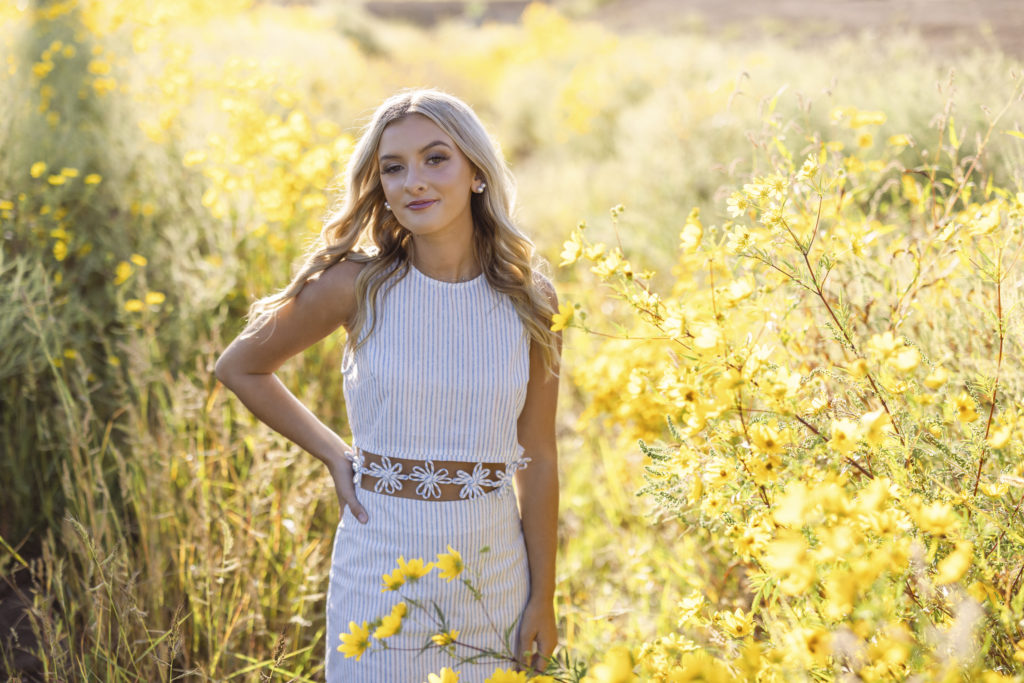 Senior portraits in NWA in a field of yellow flowers for a high school senior