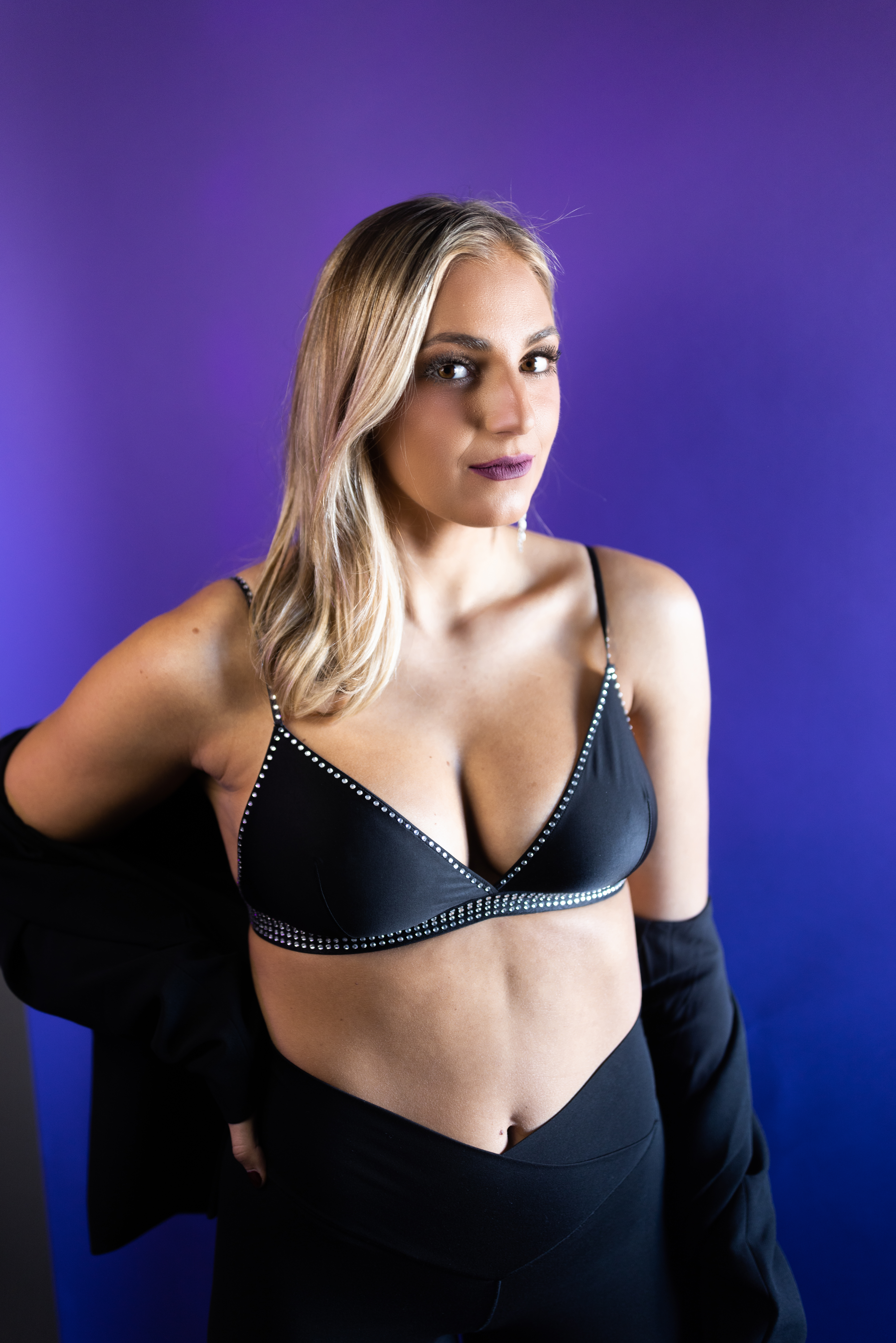 blonde model in a bra and blazer off both shoulders in the studio for her modeling portraits