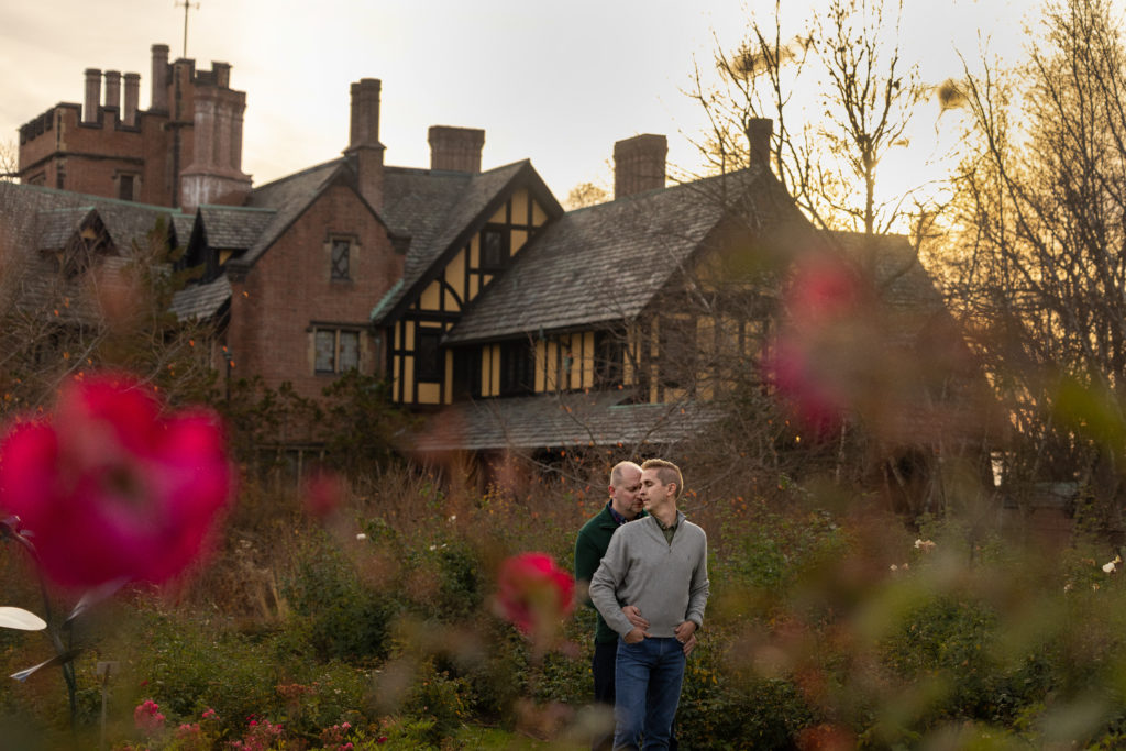 Engagement pictures at Stan Hywet of same sex gay couple in the gardens with the hall in the background. 