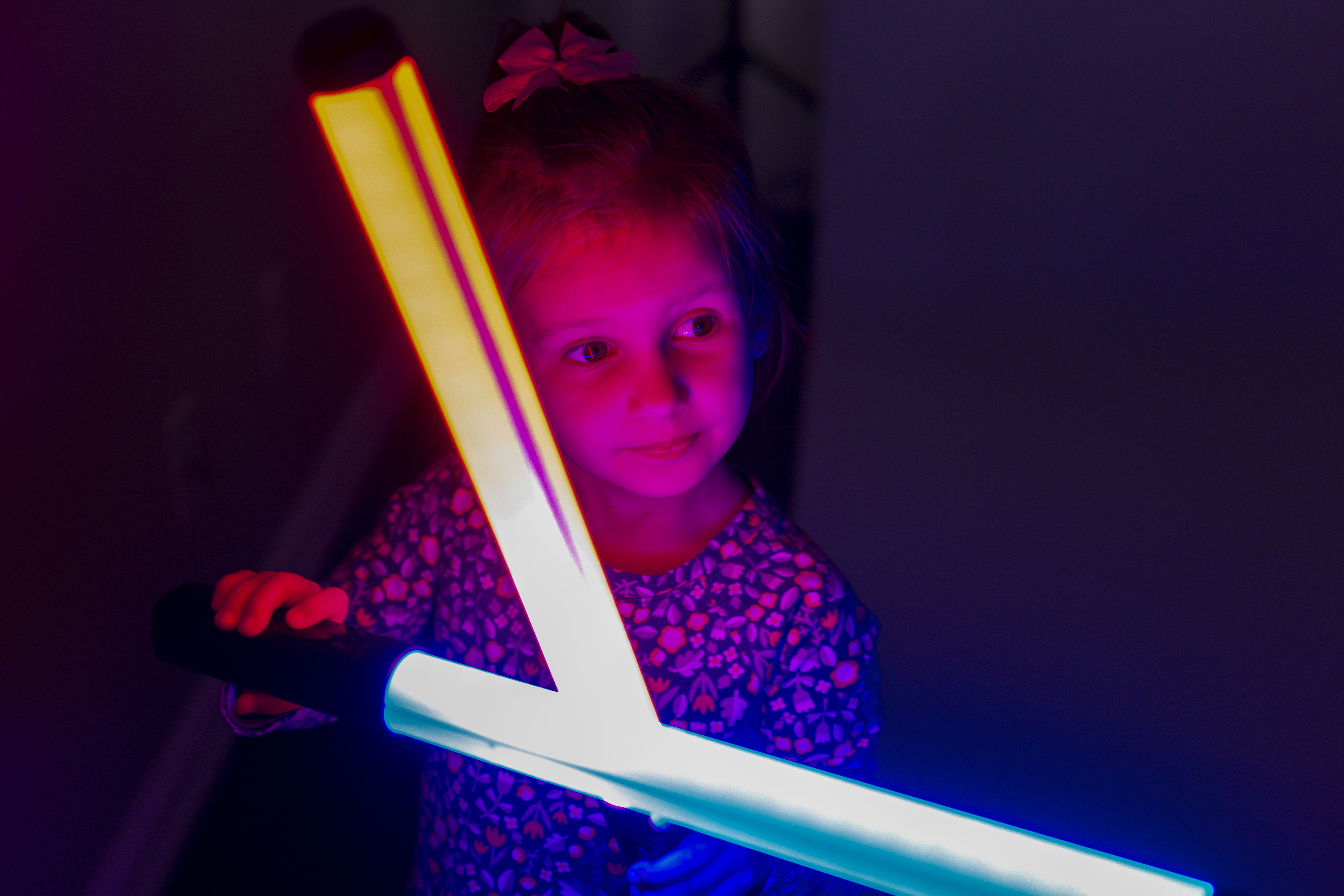 little girl with red and blue light sabers
