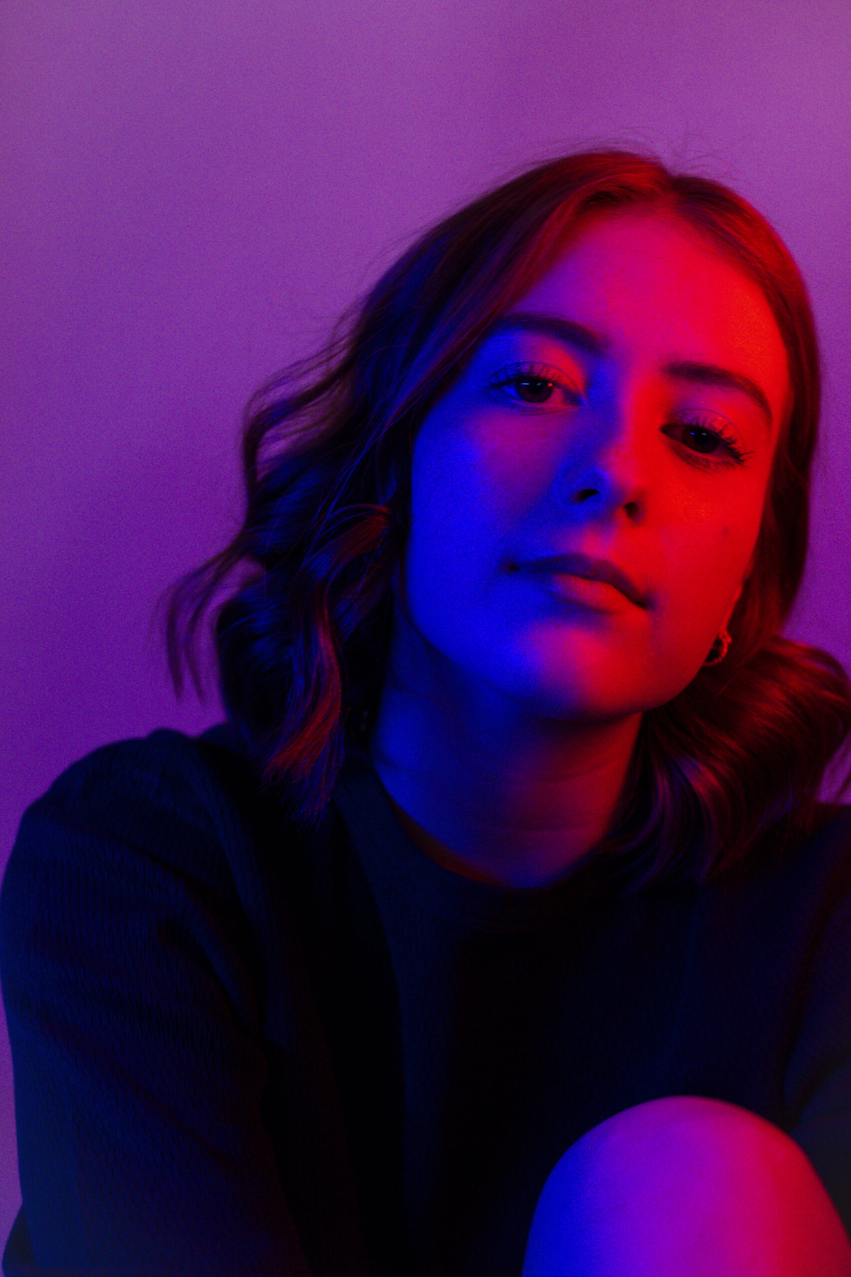 high school senior Ellie photographed in studio with red lighting