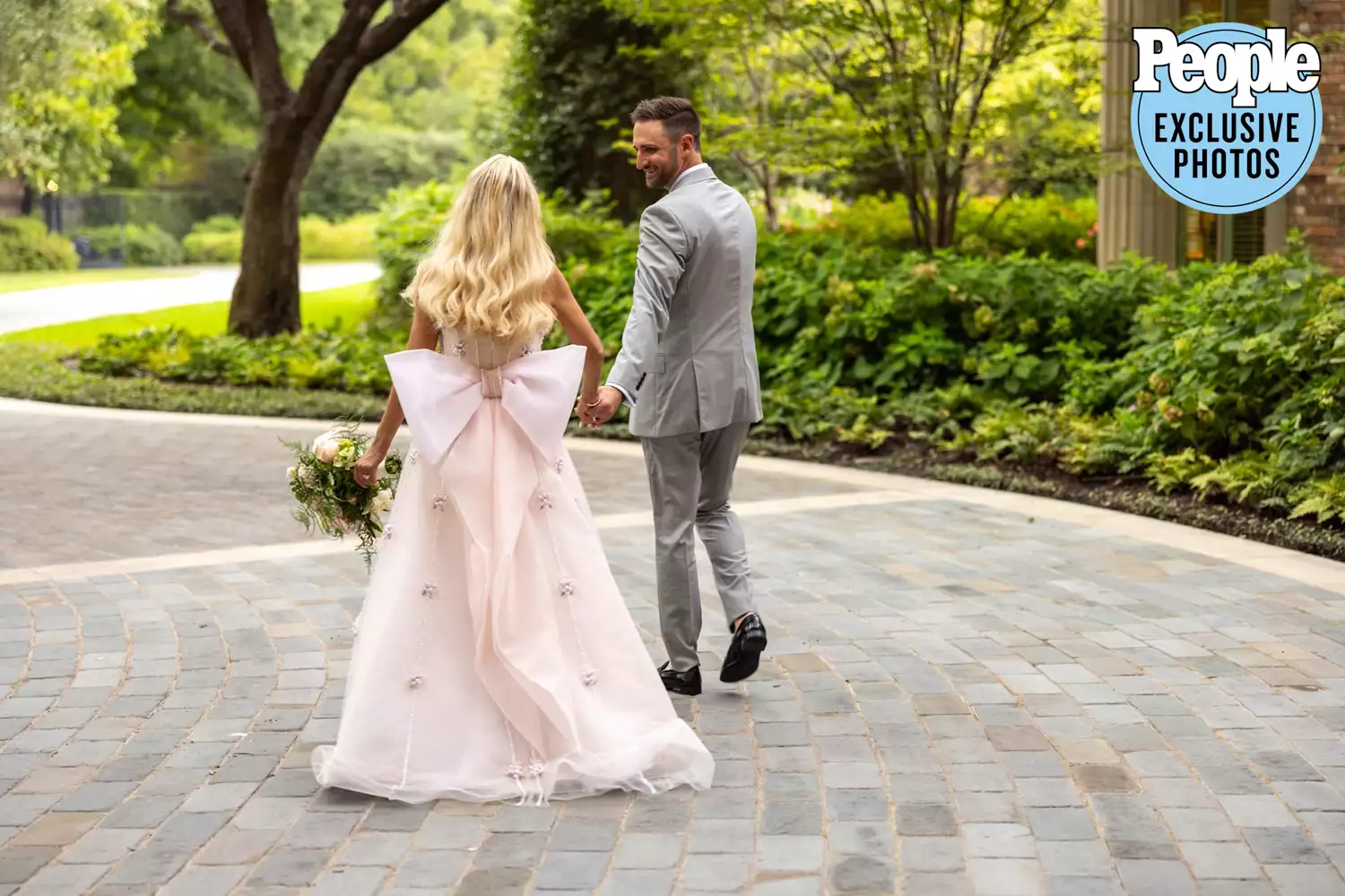 Kristin Chenoweth's wedding dress designer created a gorgeous chanel pink bow on the back, as seen here when she walks with her husband on their wedding day.