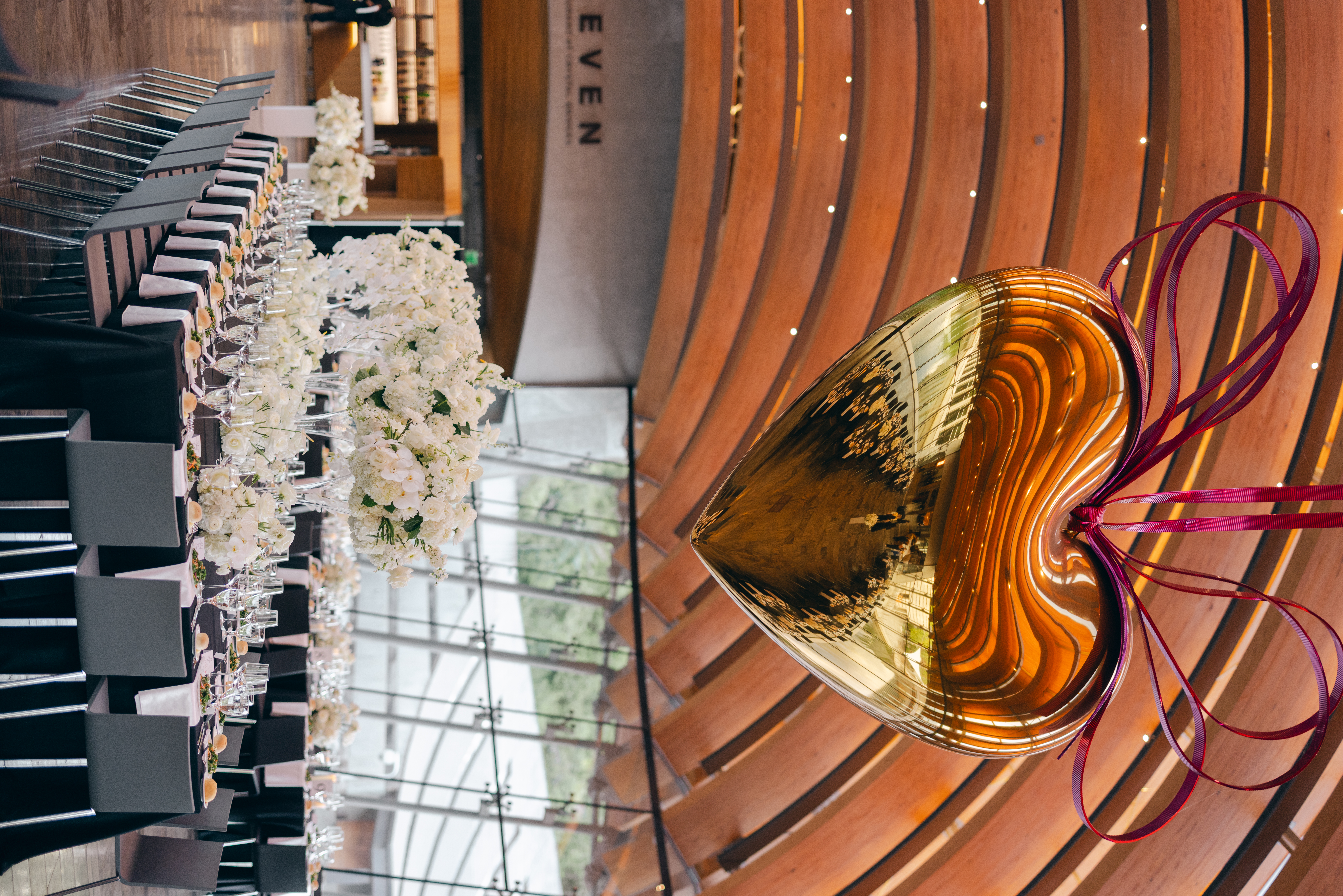 Crystal Bridges wedding details in Eleven Restaurant with an elegant table setup under the golden heart.